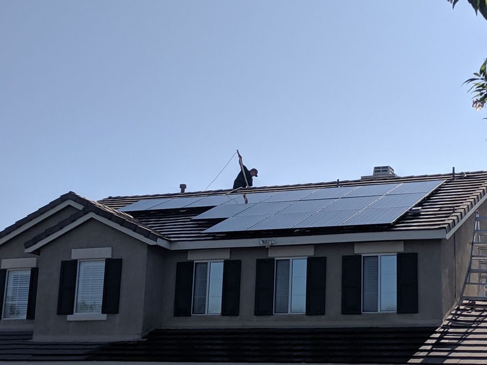 Technician cleaning a rooftop solar array